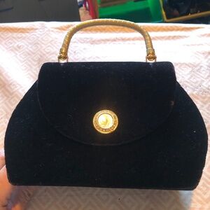 Heys international black little handbag with shoulder strap and snap closure